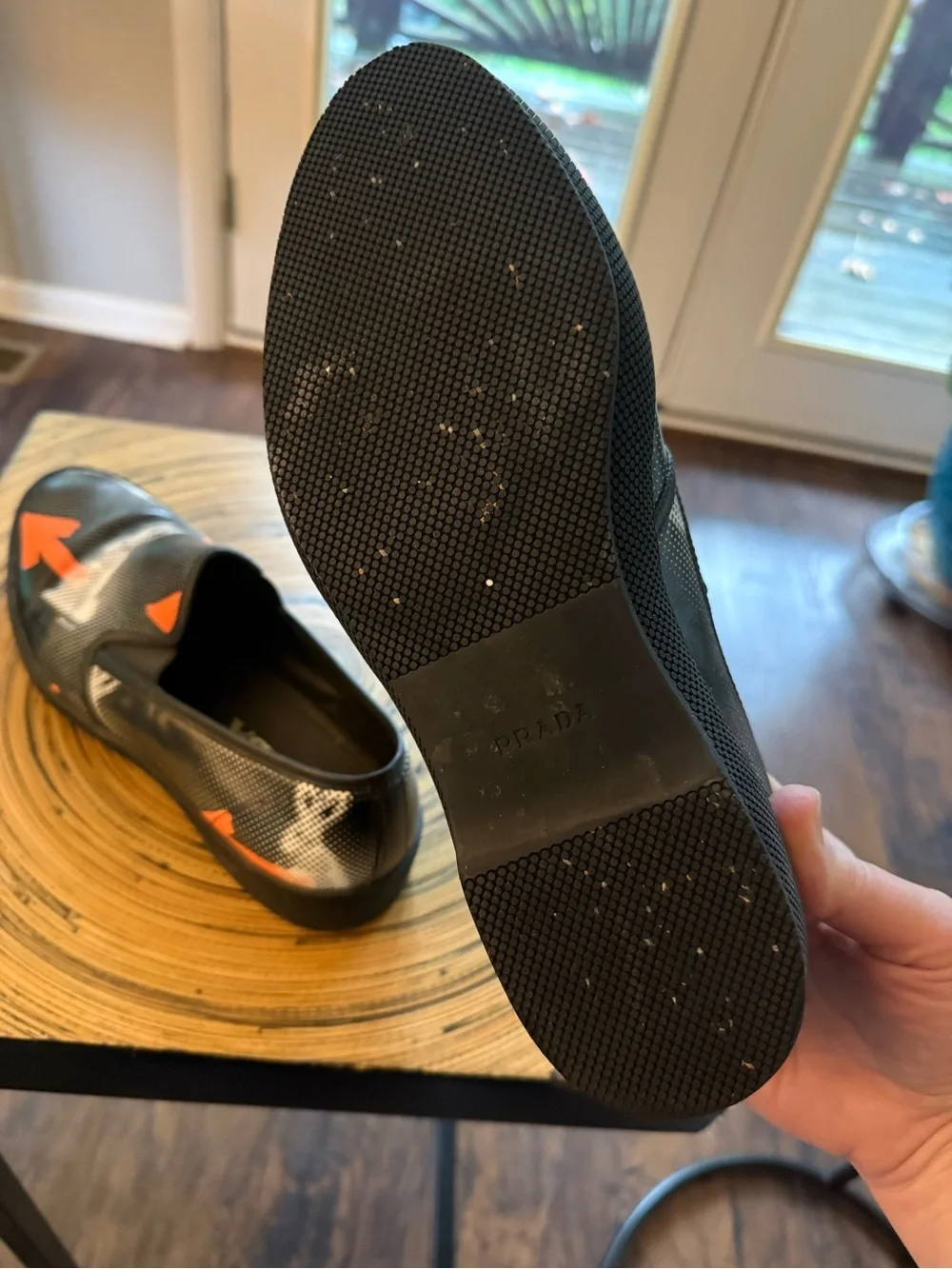 Prada Black Leather Slip-On Loafers with Orange Arrow Motif